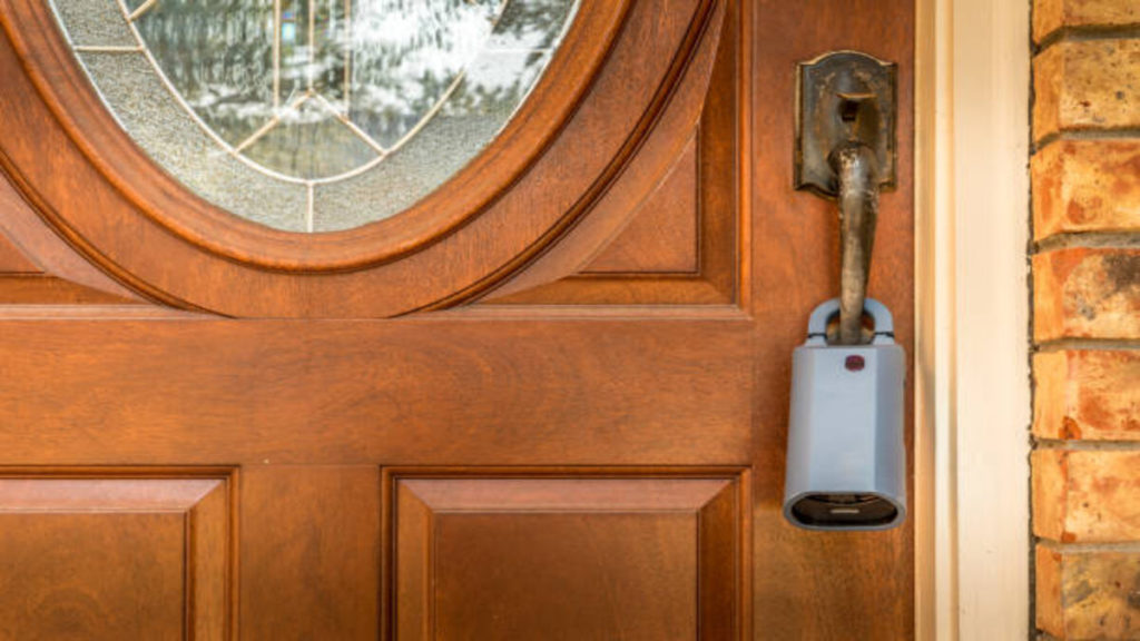 Lockbox for realtors on a door at a for sale listed house