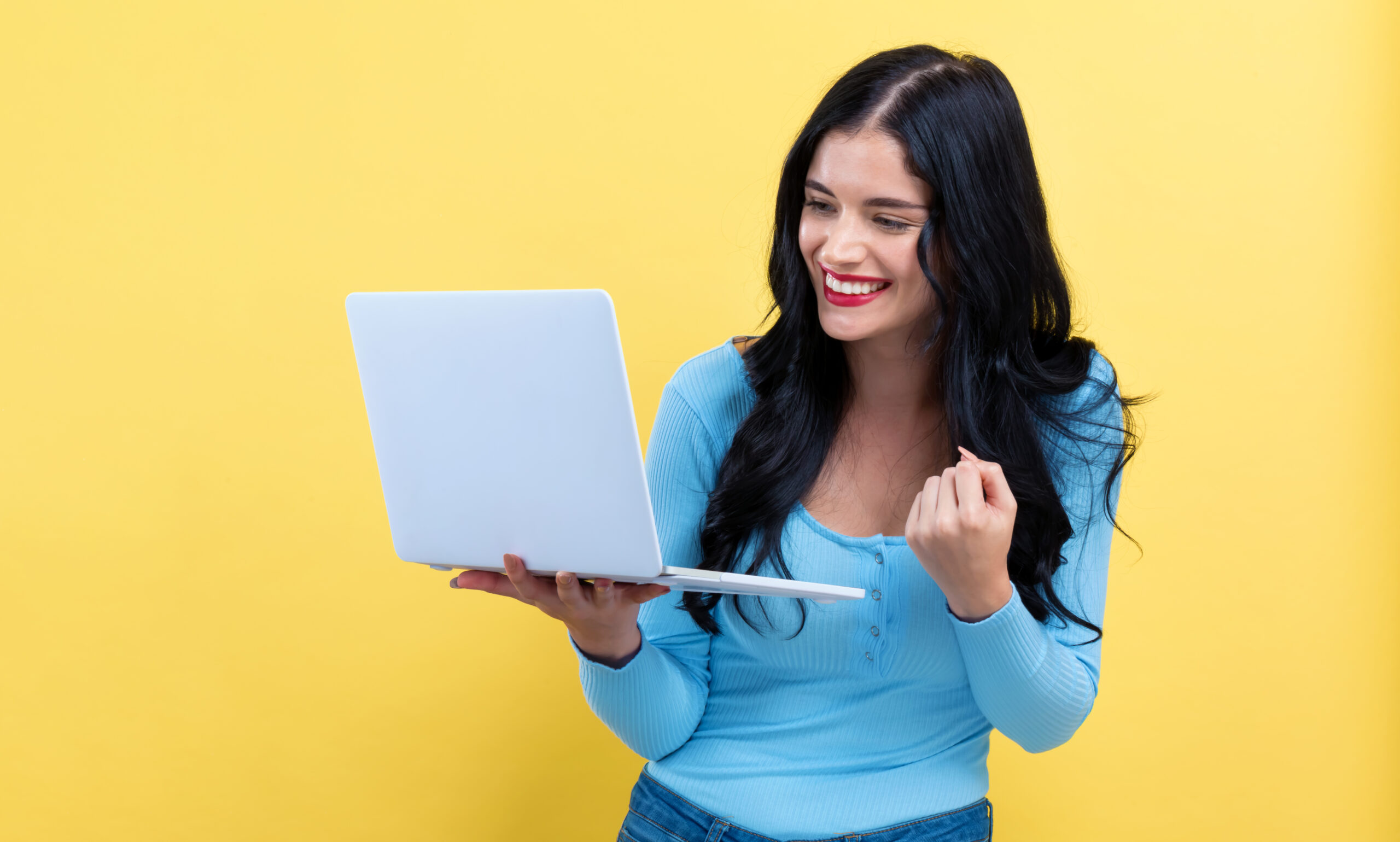 Young,Woman,With,A,Laptop,Computer,With,Successful,Pose,On